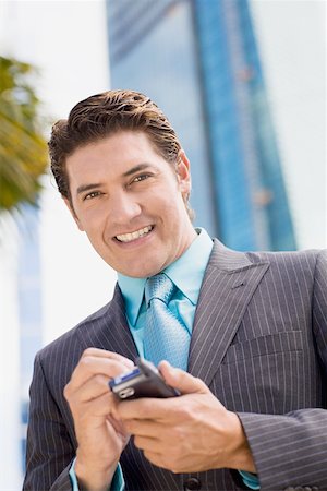 simsearch:625-01096675,k - Portrait of a businessman holding a mobile phone and smiling Stock Photo - Premium Royalty-Free, Code: 625-01748517