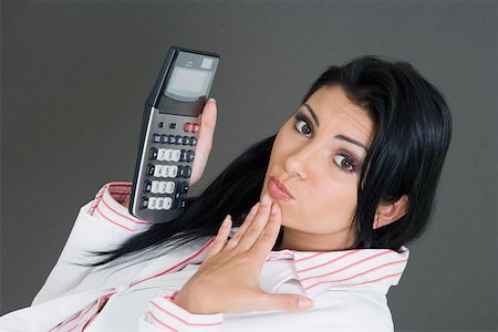 simsearch:625-01748576,k - Portrait of a businesswoman holding a calculator and making a face Foto de stock - Royalty Free Premium, Número: 625-01748569
