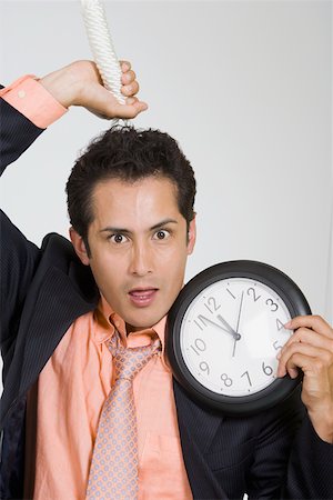 Portrait d'un homme d'affaires détenant un noeud coulant et une horloge Photographie de stock - Premium Libres de Droits, Code: 625-01748575