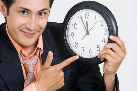 simsearch:625-01093728,k - Portrait of a businessman pointing at a clock Foto de stock - Sin royalties Premium, Código: 625-01748572