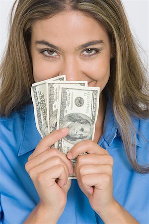 Portrait of a young woman holding American paper currency Stock Photo - Premium Royalty-Free, Code: 625-01748600