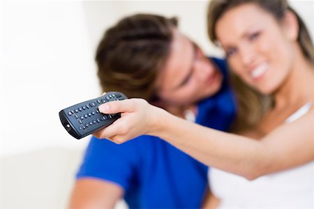 simsearch:625-02266729,k - Young woman holding a remote control with a young man kissing her Foto de stock - Sin royalties Premium, Código: 625-01748611