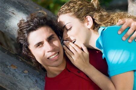 Close-up of a mid adult woman whispering into a mid adult man's ear Stock Photo - Premium Royalty-Free, Code: 625-01748651