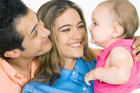 simsearch:625-02266718,k - Close-up of a young couple with their daughter smiling Fotografie stock - Premium Royalty-Free, Codice: 625-01748755