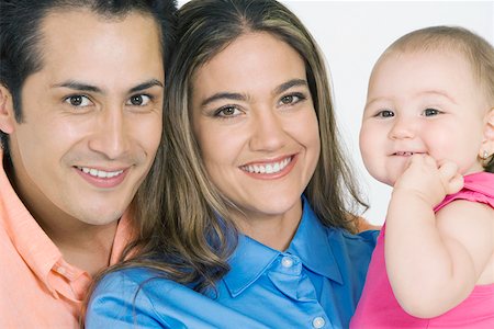 simsearch:625-02266718,k - Portrait of a young couple with their daughter smiling Fotografie stock - Premium Royalty-Free, Codice: 625-01748772