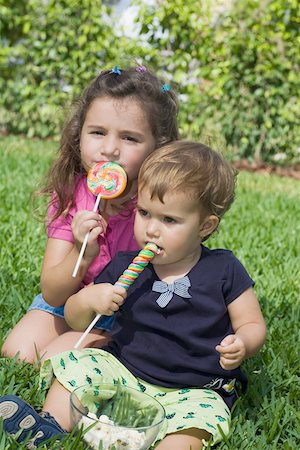 simsearch:625-01251733,k - Deux soeurs assis dans un parc et manger des bonbons Photographie de stock - Premium Libres de Droits, Code: 625-01748798