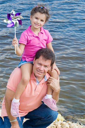 pin wheel family - Mid homme adulte portant sa fille sur ses épaules au bord de l'eau Photographie de stock - Premium Libres de Droits, Code: 625-01748827