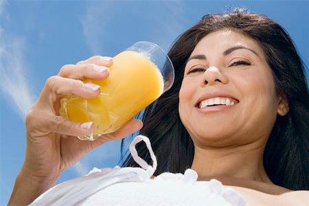 simsearch:625-00898861,k - Portrait d'une femme adulte mid tenant un verre de jus d'orange et souriant Photographie de stock - Premium Libres de Droits, Code: 625-01748833