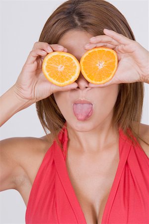 Gros plan d'une jeune femme tenant des tranches d'orange devant ses yeux Photographie de stock - Premium Libres de Droits, Code: 625-01748844