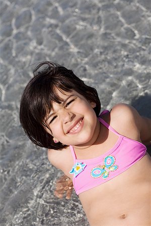 High angle view of a girl sitting in water on the beach Stock Photo - Premium Royalty-Free, Code: 625-01748876