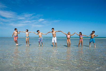 ethnic preteens swimwear girls - Children playing with holding each other hands on the beach Stock Photo - Premium Royalty-Free, Code: 625-01748919