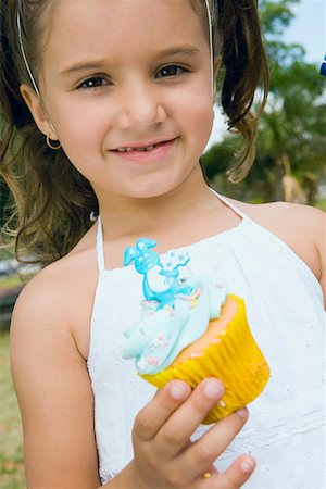simsearch:625-01251733,k - Portrait d'une jeune fille tenant un petit gâteau et souriant Photographie de stock - Premium Libres de Droits, Code: 625-01749016