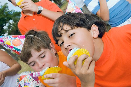 Portrait of two boys eating cupcakes Stock Photo - Premium Royalty-Free, Code: 625-01749034