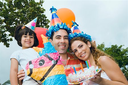 Portrait of a mid adult couple celebrating birthday with their daughter Stock Photo - Premium Royalty-Free, Code: 625-01749037