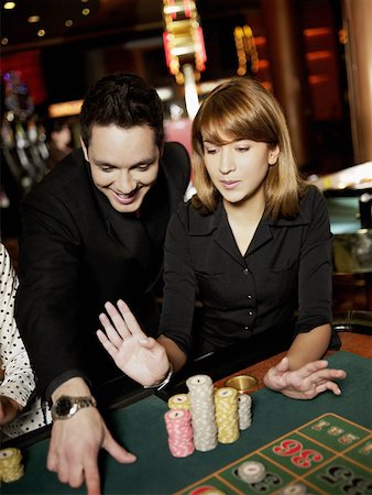 Mid adult man and a young woman gambling in a casino Stock Photo - Premium Royalty-Free, Code: 625-01749118