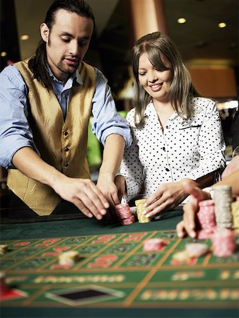 simsearch:625-01749180,k - Casino worker arranging gambling chips for a young woman in a casino Stock Photo - Premium Royalty-Free, Code: 625-01749132