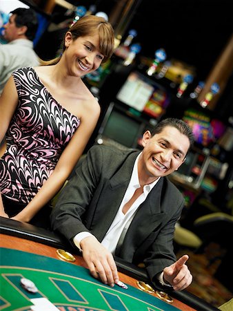 Mid adult man gambling in a casino and a young woman standing beside him Stock Photo - Premium Royalty-Free, Code: 625-01749185