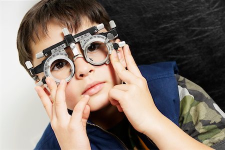 Close-up of a boy wearing phoropter in a doctor's office Stock Photo - Premium Royalty-Free, Code: 625-01749189