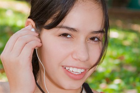simsearch:625-01748196,k - Porträt einer jungen Frau hält ein Ohrhörer und Lächeln Stockbilder - Premium RF Lizenzfrei, Bildnummer: 625-01749343