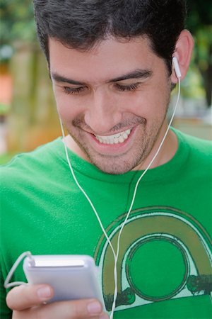 Close-up of a young man listening to an MP3 player Stock Photo - Premium Royalty-Free, Code: 625-01749358