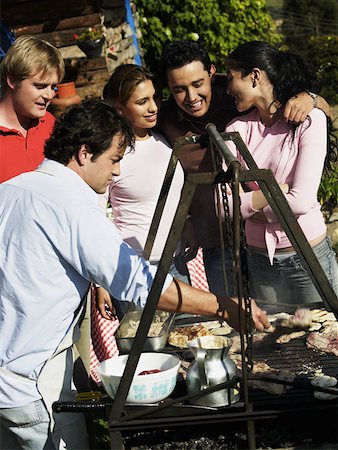 simsearch:625-01748962,k - Mid homme adulte, préparation des aliments dans un barbecue avec quatre personnes debout à côté de lui Photographie de stock - Premium Libres de Droits, Code: 625-01749397
