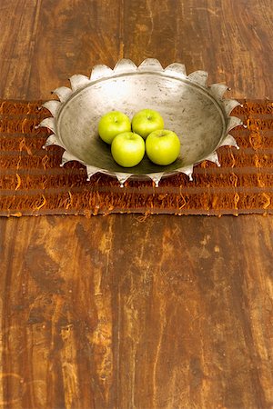 High angle view of four apples in a bowl at a dining table Stock Photo - Premium Royalty-Free, Code: 625-01743677