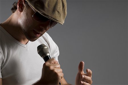 Close-up of a young man singing into a microphone Stock Photo - Premium Royalty-Free, Code: 625-01743989