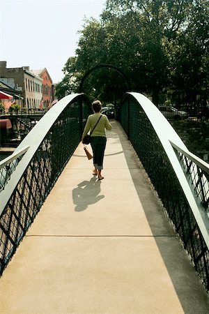 savannah - Rear view of a woman walking on a footbridge, Savannah, Georgia, USA Foto de stock - Sin royalties Premium, Código: 625-01750391