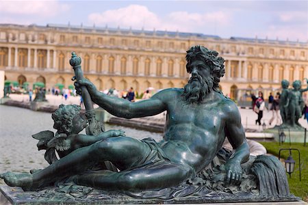 Close-up of a statue with a palace in the background, Statue Of Neptune, Palace of Versailles, Versailles, France Fotografie stock - Premium Royalty-Free, Codice: 625-01750590