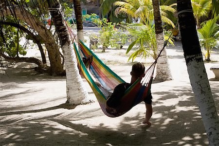 Rear view of a man lying in a hammock, Coral Cay, Dixon Cove, Roatan, Bay Islands, Honduras Foto de stock - Sin royalties Premium, Código: 625-01751970