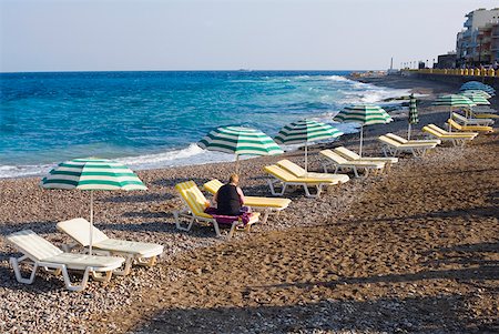 Beach umbrellas and lounge chairs on the beach, Lindos, Rhodes, Dodecanese Islands, Greece Stock Photo - Premium Royalty-Free, Code: 625-01752208