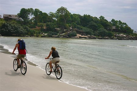Rear view of a couple riding bicycles on the beach, Sihanoukville, Cambodia Stock Photo - Premium Royalty-Free, Code: 625-01752733