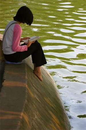 Side profile of a girl reading a book at the riverside, Hanoi, Vietnam Stock Photo - Premium Royalty-Free, Code: 625-01753085