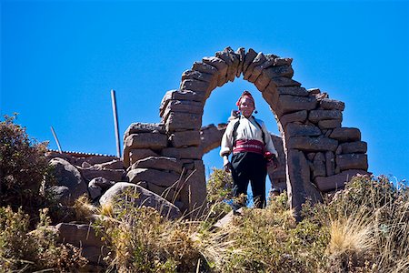 simsearch:625-01753293,k - Portrait of a young woman standing under a stone arch, Taquile Island, Lake Titicaca, Puno, Peru Fotografie stock - Premium Royalty-Free, Codice: 625-01753476