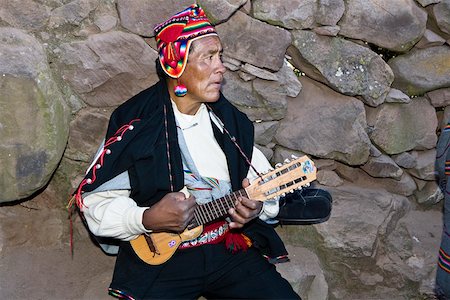 south america costumes male - Close-up of a senior man playing a ukulele, Taquile Island, Lake Titicaca, Puno, Peru Stock Photo - Premium Royalty-Free, Code: 625-01753496