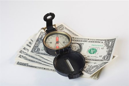 Close-up of a compass on a stack of US dollar bills Stock Photo - Premium Royalty-Free, Code: 625-02265918