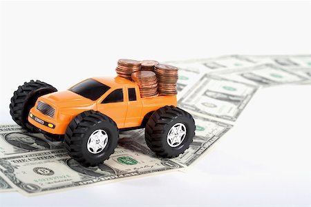 simsearch:625-02266093,k - Close-up of a pick-up truck on a road made of US dollar bills Fotografie stock - Premium Royalty-Free, Codice: 625-02265943
