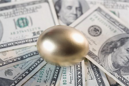 simsearch:625-02266093,k - Close-up of a golden egg on US paper currency Fotografie stock - Premium Royalty-Free, Codice: 625-02265954