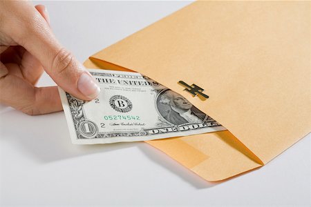 simsearch:6109-06007163,k - Close-up of a person's hand picking out a US dollar bill from an envelope Fotografie stock - Premium Royalty-Free, Codice: 625-02265951