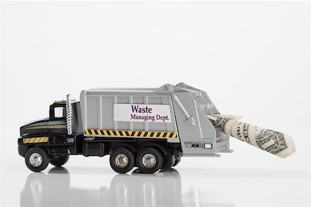 Close-up of toy garbage truck carrying US dollar bill Stock Photo - Premium Royalty-Free, Code: 625-02266081