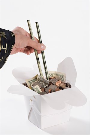 Close-up of a person's hand picking coins with chopsticks Stock Photo - Premium Royalty-Free, Code: 625-02266082