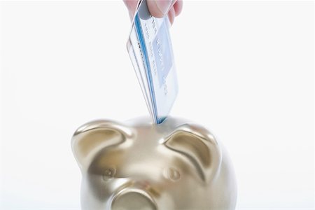 simsearch:625-02265907,k - Close-up of a person's hand putting a credit card into a piggy bank Stock Photo - Premium Royalty-Free, Code: 625-02266119