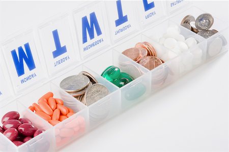 Boîte de calendrier de médicaments sur ordonnance contenant des pièces de monnaie et capsules Photographie de stock - Premium Libres de Droits, Code: 625-02266126