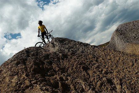 extreme teen - Low angle view of a young man mountain biking Stock Photo - Premium Royalty-Free, Code: 625-02266369