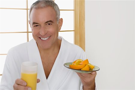 simsearch:625-01096495,k - Portrait of a senior man holding a plate of oranges and a glass of orange juice Fotografie stock - Premium Royalty-Free, Codice: 625-02266503