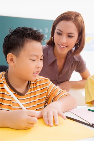 studying young asian boy - Female teacher teaching her student in a classroom Stock Photo - Premium Royalty-Free, Code: 625-02266533