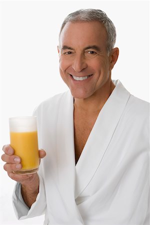 Portrait of a senior man holding a glass of orange juice and smiling Stock Photo - Premium Royalty-Free, Code: 625-02266544