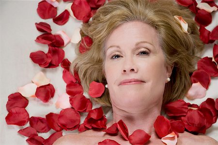 Portrait of a mature woman lying on a massage table with rose petals on her body Stock Photo - Premium Royalty-Free, Code: 625-02266545