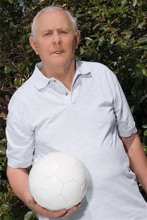 simsearch:625-02931670,k - Portrait d'un homme supérieur tenant un ballon de soccer Photographie de stock - Premium Libres de Droits, Code: 625-02266558