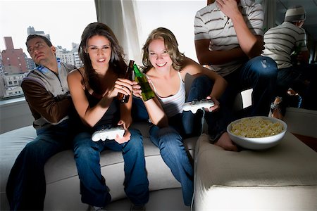 simsearch:625-02266729,k - Young women playing a video game and toasting with beer bottles Foto de stock - Sin royalties Premium, Código: 625-02266640